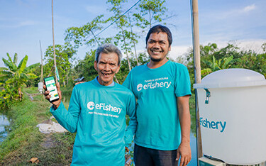 eFishery Co-Founder and CEO Gibran Huzaifah with a shrimp farmer.