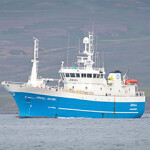 A fishing vessel heading out to sea.