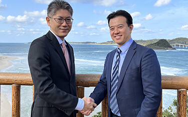 Brian Tsuyoshi Takeda of Urchinomics shakes hands with Yasunori Yazaki of ENEOS holdings.