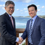 Brian Tsuyoshi Takeda of Urchinomics shakes hands with Yasunori Yazaki of ENEOS holdings.