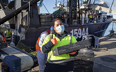 A Sanford Limited employee holding a box of the company's Scampi.