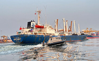 The Sun Flower 7 being escorted out of the port of Bangkok by Thai police.