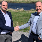 Officials with Agrilight and Lakesystemer shake hands.