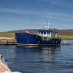 A wellboat tending to salmon net pens in Scotland.