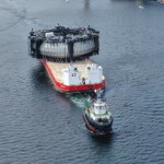 The 600-metric-ton Marine Donut salmon farm being towed out to sea on a barge.