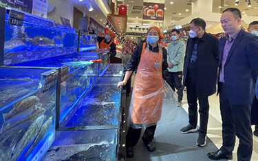 Tongwei Food President Chen Bo, Deputy General Manager Xue Feng, and Director Huang Jinsong tour a supermarket in China.