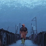 An Australis worker walking on one of the company's net pens.