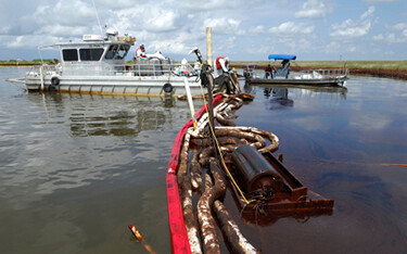 Officials with NOAA fisheries working to clean up an oil spill in the water.