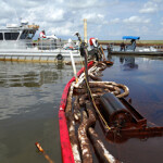 Officials with NOAA fisheries working to clean up an oil spill in the water.