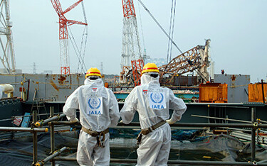 Two IAEA experts examining recovery work at the Fukushima Daiichi Nuclear Power Station.