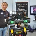 A Submerged employee posing next to a display of the company's Rolleye system.