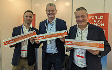 Representatives of the Salma salmon brand posing with their products.