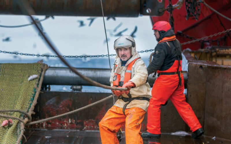A pair of Polar Seafood fishermen at work on a boat