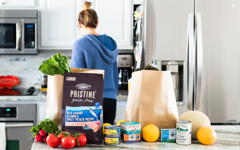 A woman in a kitchen with bags of MSC-certified seafood products