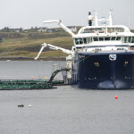 A vessel attending to a Scottish salmon farm's net pen
