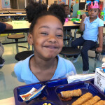 A kid in a U.S. school with fish sticks on their plate