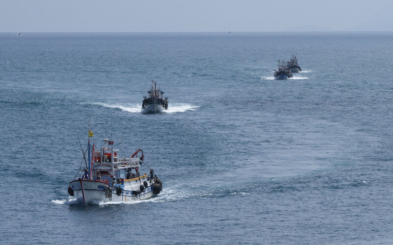 A series of Taiwanese fishing vessels sailing in a line