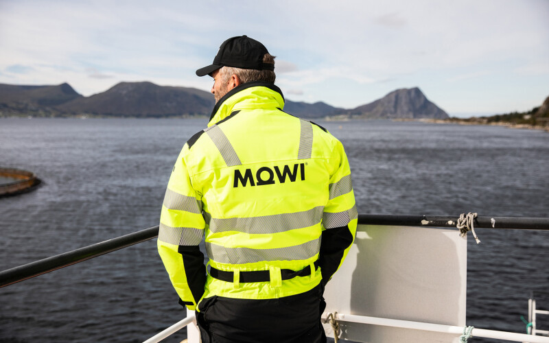 A Mowi employee standing near a railing at a salmon farm