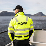 A Mowi employee standing near a railing at a salmon farm