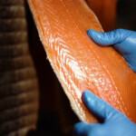 A worker handling some of Associated Seafoods' smoked salmon