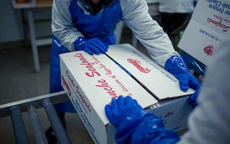 Conche Seafoods workers packaging crab in a box