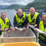 Philip Gillibrand, Sean Anderson, Allan Murdoch, and Luke Plummer pose with salmon smolt
