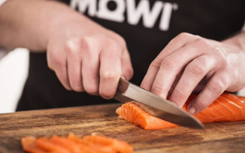 A chef cutting a Mowi salmon fillet