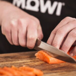 A chef cutting a Mowi salmon fillet