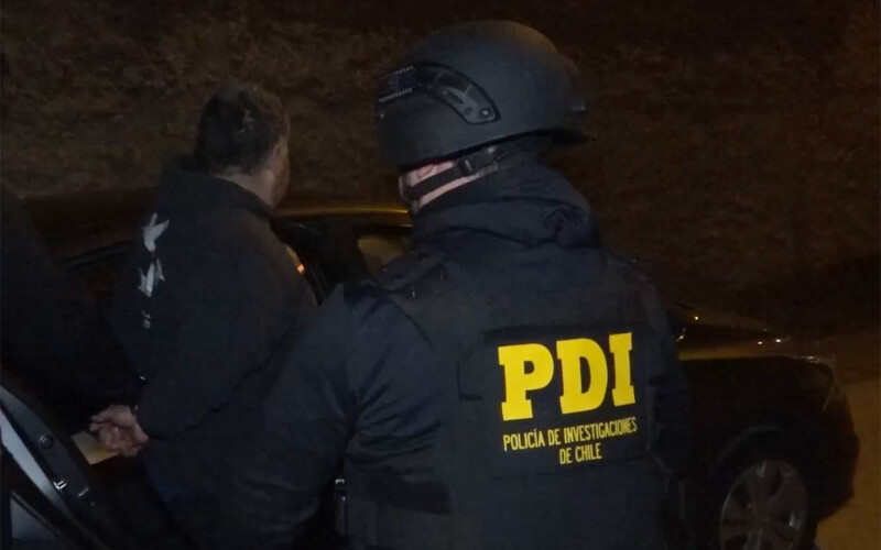 A Chilean policeman arresting a member of a criminal organization that stole salmon destined for export