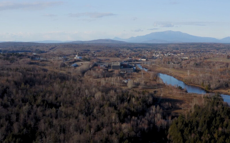 An aerial view of the proposed site for Great Northern Salmon's salmon RAS project, with Mt. Katahdin in the background