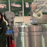 Jaw Feng Overseas Division Manager Mary Kuo standing next to a vacuum-packaging machine