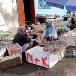 A woman selling shrimp at an outdoor market in Indonesia