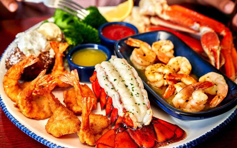 A spread of Red Lobster products including lobster tail, grilled shrimp, and coconut shrimp