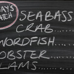 A photo of a handwritten menu at a restaurant displaying the seafood catch it is offering