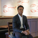 Newly appointed Red Lobster CEO Damola Adamolekun sitting on a chair inside a Red Lobster restaurant