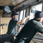 Two Canadian Coast Guard officers on the bridge of the Sir Wilfrid Laurier looking out the windows with binoculars