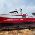 A photo of the red-and white colored Inuksuk II, an 80-meter long fishing vessel, at a dock.