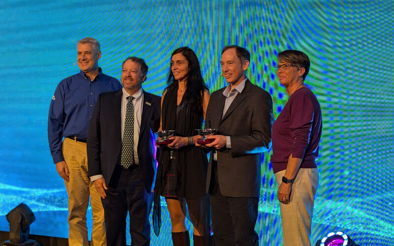 The two winners of the Responsible Seafood Innovation Awards stand on stage in St. Andrews, Scotland