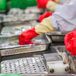 Workers inside a Vietnamese shrimp-processing facility wearing protective gear.