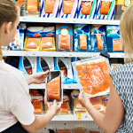 Two women buying packaged seafood in a retail store