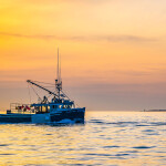 A lobster boat in Nova Scotia sailing at sunrise.