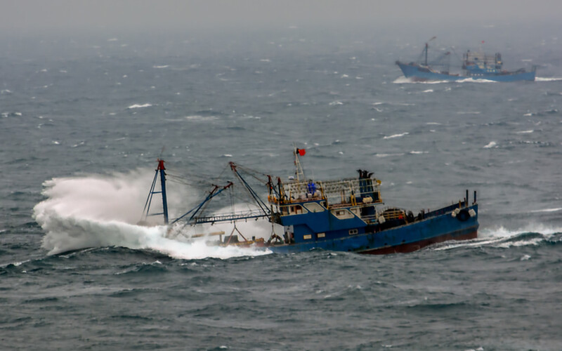 A fishing trawler pounding through waves in the South China Sea
