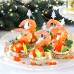 Five canapes with avocado, shrimp, and salmon roe with Christmas-themed decorations