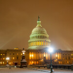 A nighttime photo of the U.S. capitol building in the snow.