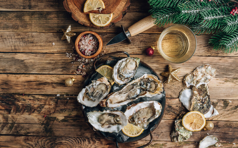 A plate of oysters with Christmas decor around it