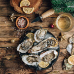 A plate of oysters with Christmas decor around it
