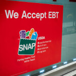 A sign outside of a 7-Eleven convenience store in New York City stating that the store accepts SNAP benefits