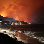 The coastline of Malibu, California, U.S.A., with the Palisades fire raging in the distance
