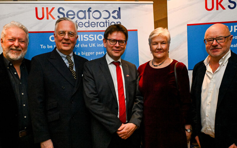 Members of the UK Seafood Federation in front of a banner featuring the new organization's logo