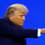 U.S. President Donald Trump pointing offscreen with a blue blackground.